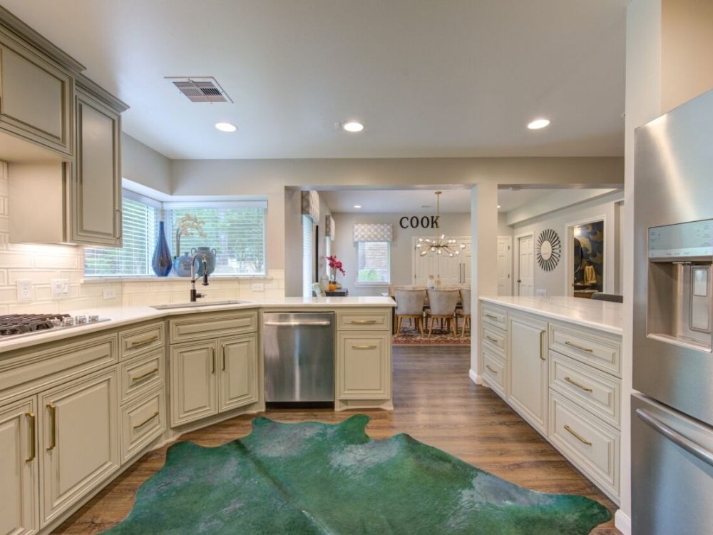 Custom luxury kitchen featuring elegant cabinetry, modern appliances, and a stylish green area rug, showcasing Trinity Construction's high-quality craftsmanship and design.